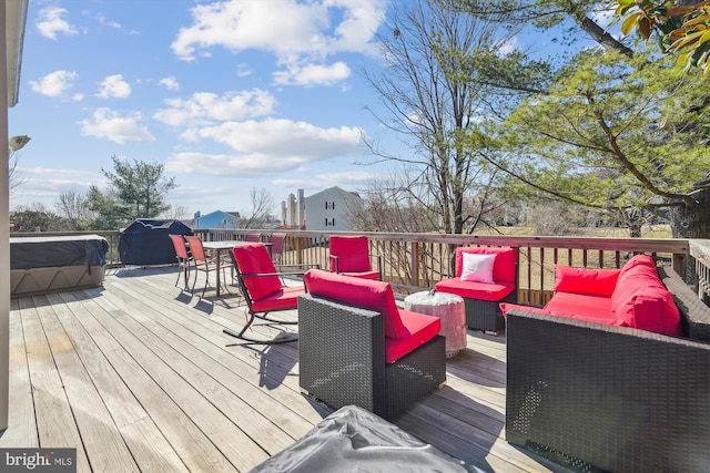 wooden terrace featuring outdoor lounge area and a hot tub