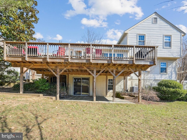 rear view of property with a patio, a lawn, and a deck