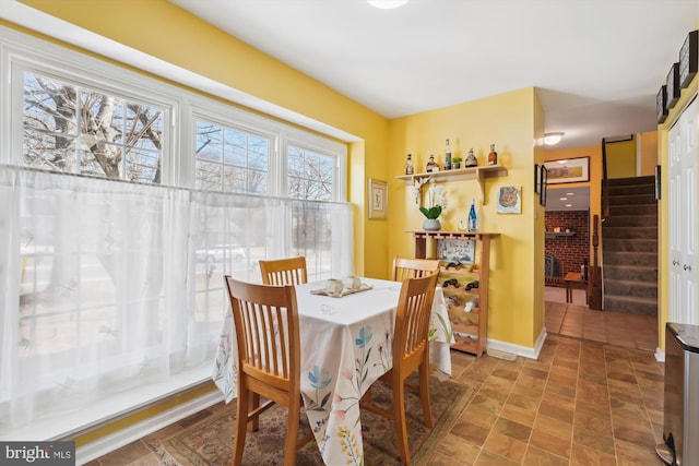 dining area featuring baseboards and stairs