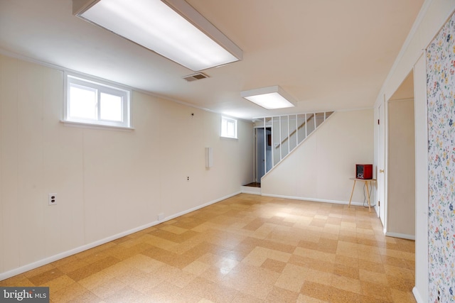 basement with a wealth of natural light, visible vents, light floors, and stairs