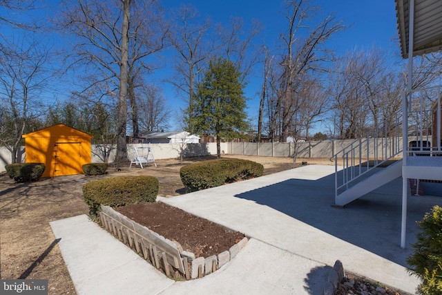 view of yard featuring an outbuilding, a fenced backyard, a patio, and a storage unit