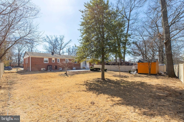 view of yard featuring a fenced backyard, a shed, a patio, and an outdoor structure