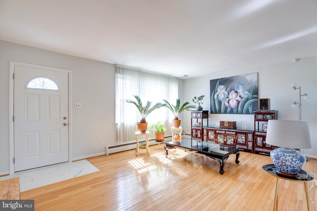 entrance foyer featuring a baseboard radiator, wood-type flooring, and baseboards