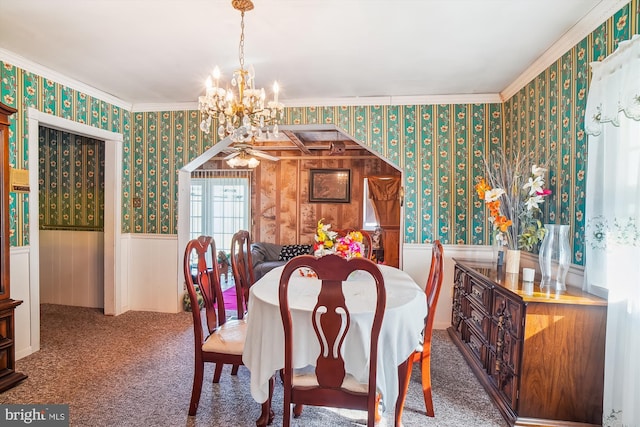 carpeted dining room with a chandelier, a wainscoted wall, wallpapered walls, and crown molding