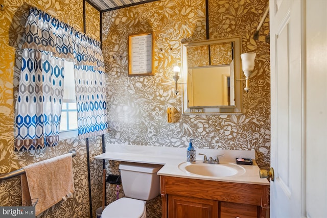 bathroom featuring wallpapered walls, toilet, and vanity