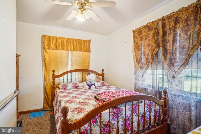 carpeted bedroom with ceiling fan and baseboards