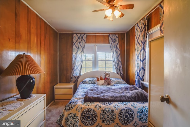 carpeted bedroom featuring wood walls and ornamental molding