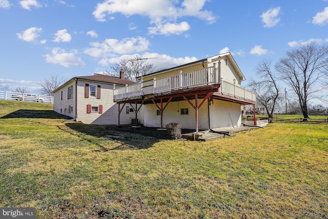 rear view of house with a deck and a yard