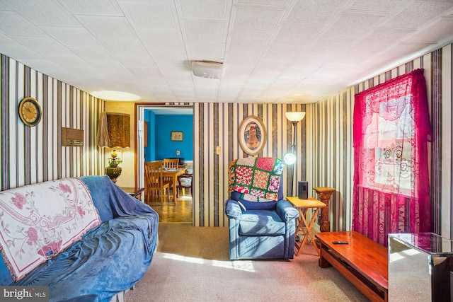 carpeted living area featuring wallpapered walls