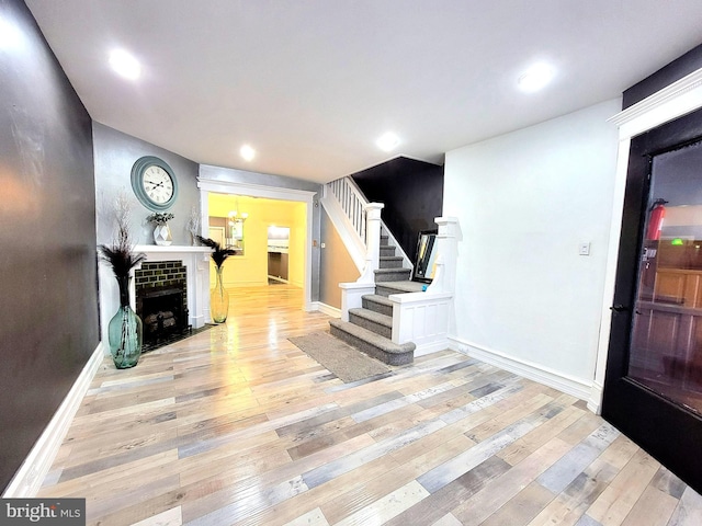 entryway featuring a tile fireplace, recessed lighting, baseboards, stairs, and hardwood / wood-style floors