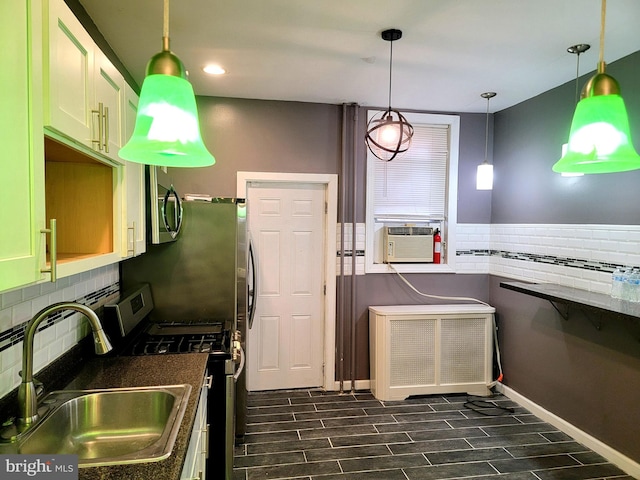 kitchen with cooling unit, a sink, appliances with stainless steel finishes, wood tiled floor, and dark countertops