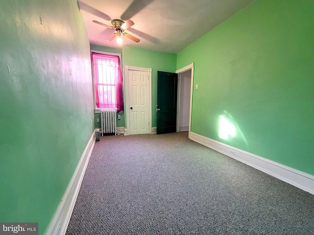 unfurnished bedroom with baseboards, carpet, a ceiling fan, and radiator