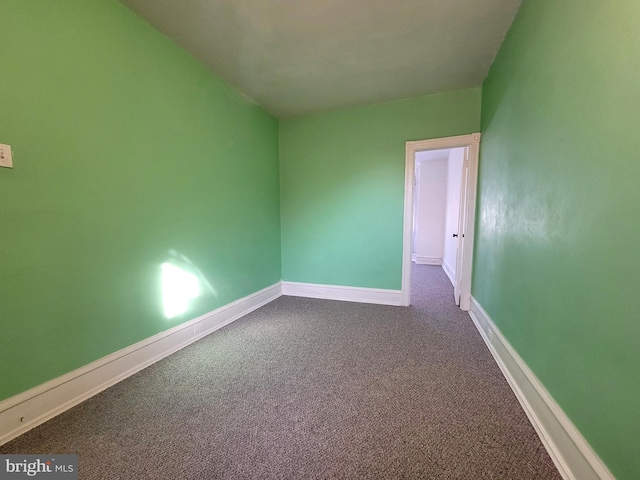 spare room featuring carpet and baseboards