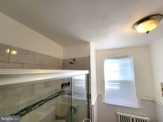 full bathroom featuring radiator and a shower stall