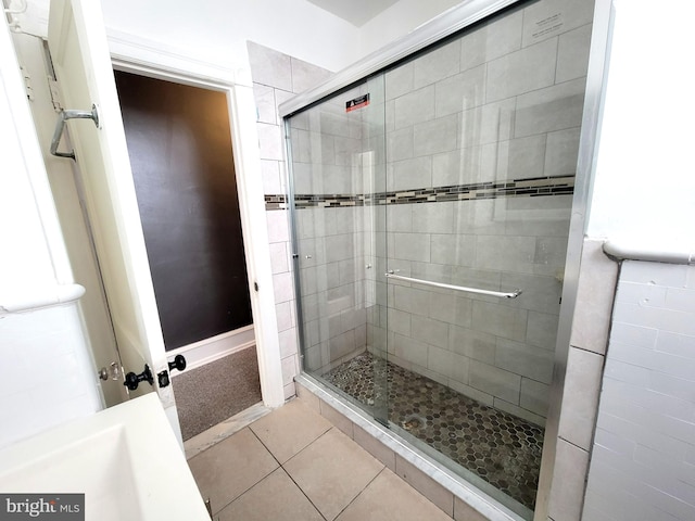 full bath with tile patterned flooring and a shower stall