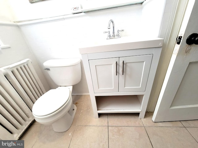 bathroom with radiator, vanity, toilet, and tile patterned floors