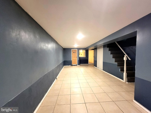 finished basement with light tile patterned floors and stairs