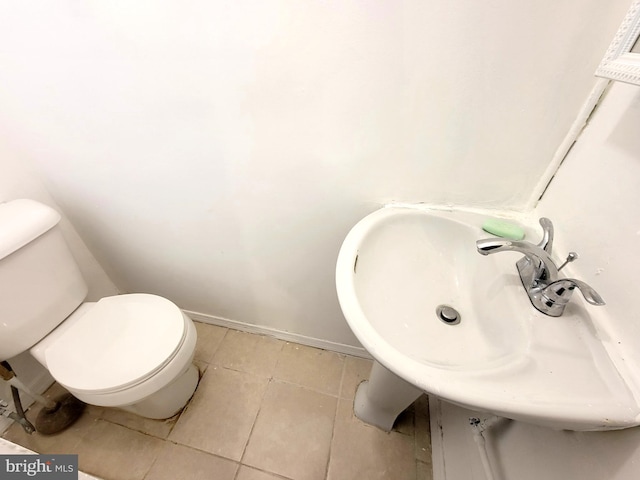 bathroom featuring a sink, tile patterned flooring, toilet, and baseboards