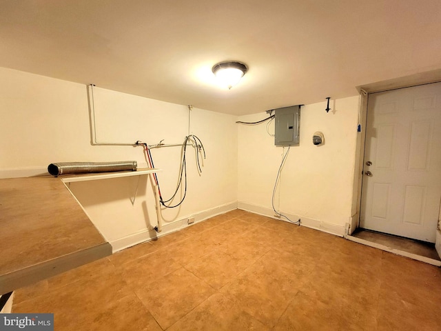 laundry area featuring electric panel and baseboards