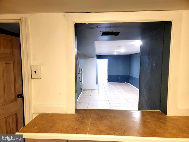 corridor with tile patterned flooring and baseboards