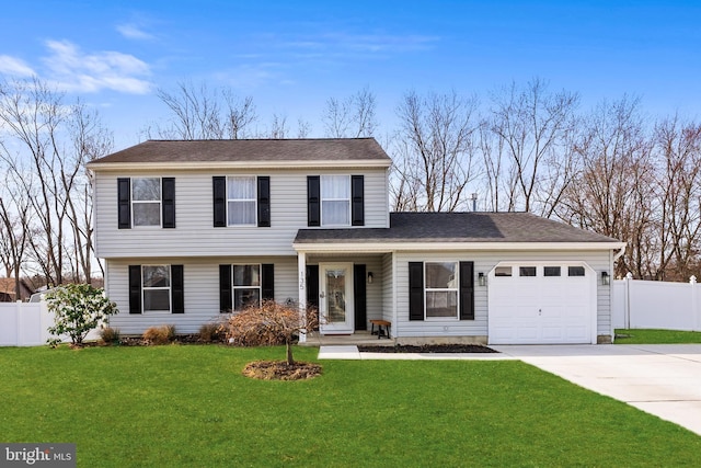 colonial home with fence, driveway, an attached garage, a shingled roof, and a front lawn