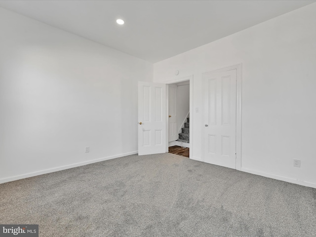 carpeted spare room with stairs, recessed lighting, and baseboards