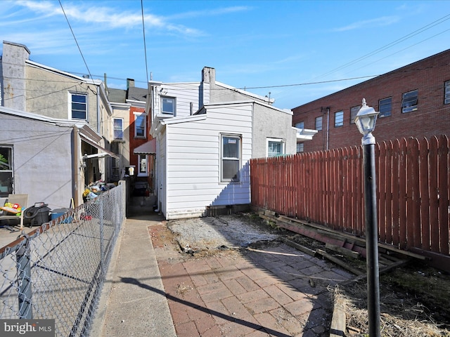 back of house with a fenced backyard