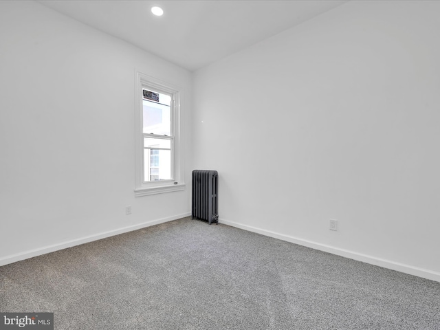 carpeted spare room with radiator, recessed lighting, and baseboards