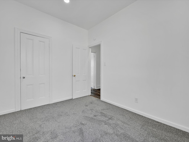 unfurnished bedroom featuring carpet flooring and baseboards