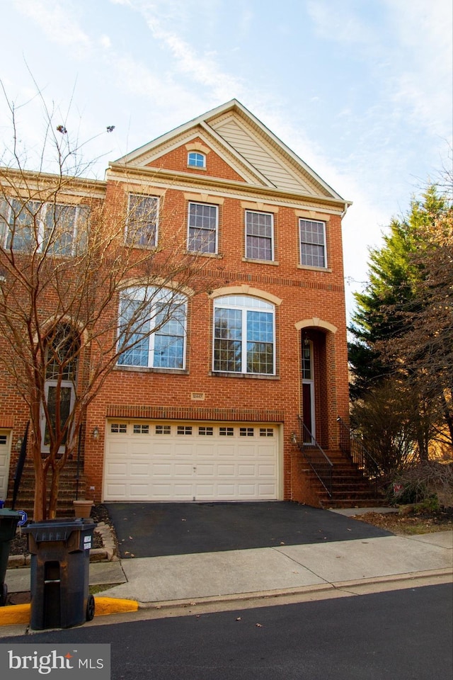 view of front of home featuring a garage, aphalt driveway, and brick siding