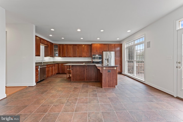 kitchen with a kitchen bar, a kitchen island, stainless steel appliances, and recessed lighting