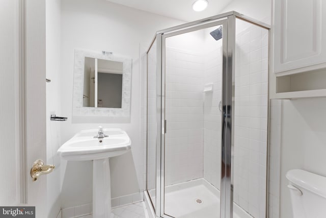 bathroom featuring toilet and a shower stall