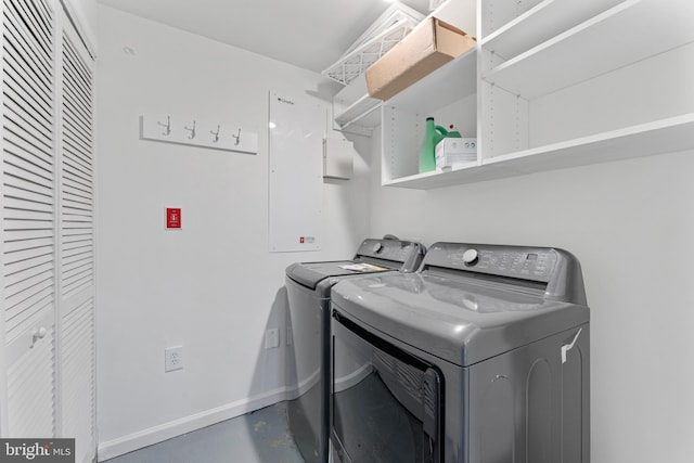 laundry room featuring laundry area, washing machine and clothes dryer, and baseboards