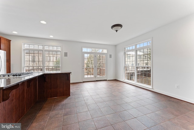 kitchen featuring recessed lighting, tile patterned flooring, stainless steel gas stovetop, and baseboards