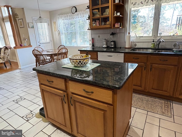 kitchen with dishwasher, a healthy amount of sunlight, a sink, and decorative backsplash