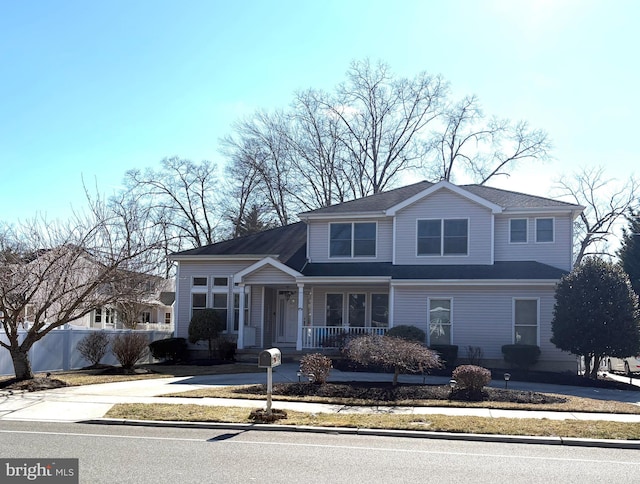 view of front of home with covered porch and fence