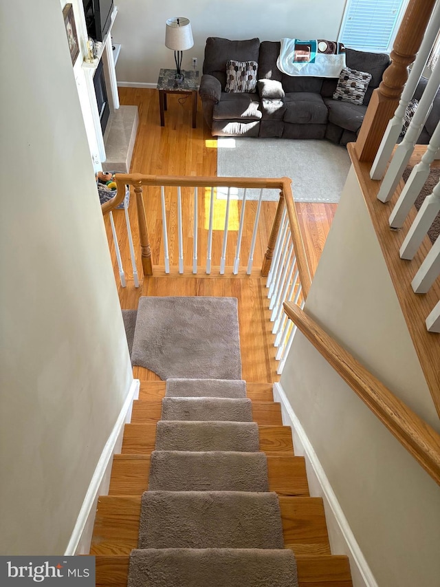 stairs with baseboards and wood finished floors