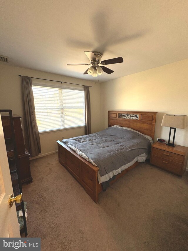 carpeted bedroom with ceiling fan and visible vents