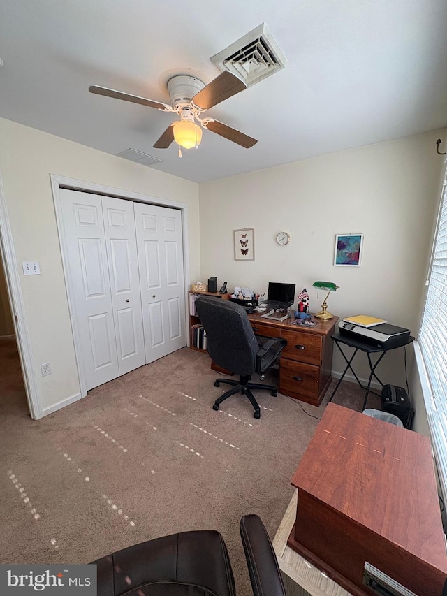 carpeted office with ceiling fan, visible vents, and baseboards