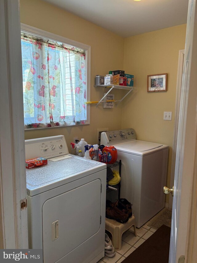 laundry area with laundry area, light tile patterned floors, and washer and dryer