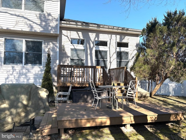 rear view of house with fence and a deck