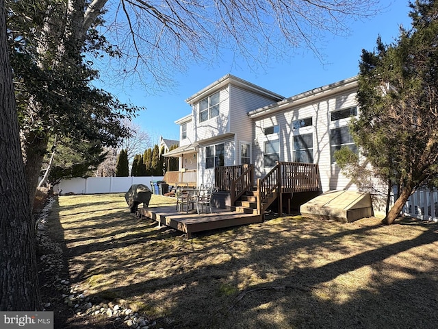 back of house featuring fence and a deck