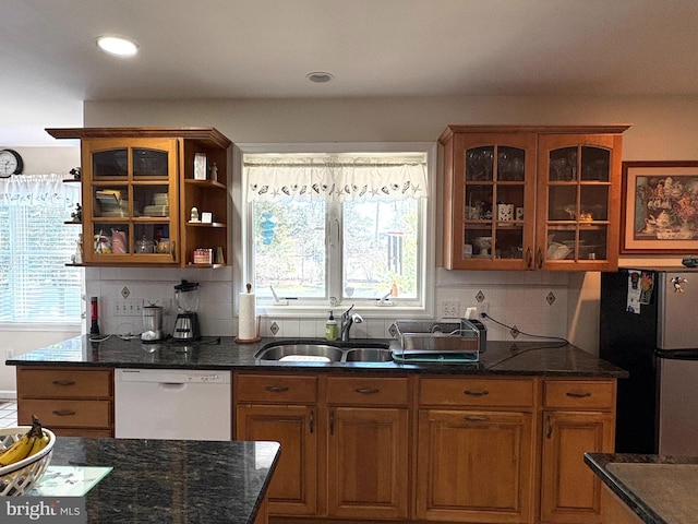 kitchen with a sink, a wealth of natural light, dishwasher, and freestanding refrigerator