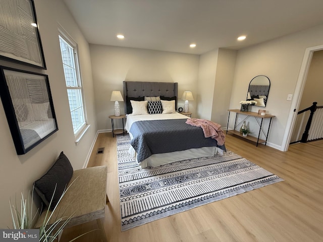 bedroom with recessed lighting, wood finished floors, visible vents, and baseboards