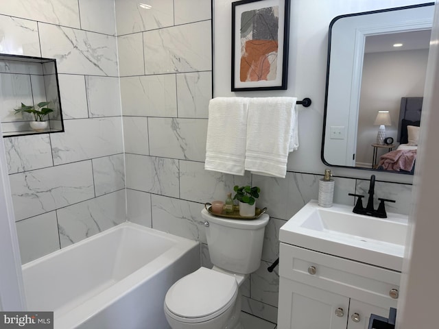 bathroom with tile walls, vanity, and toilet