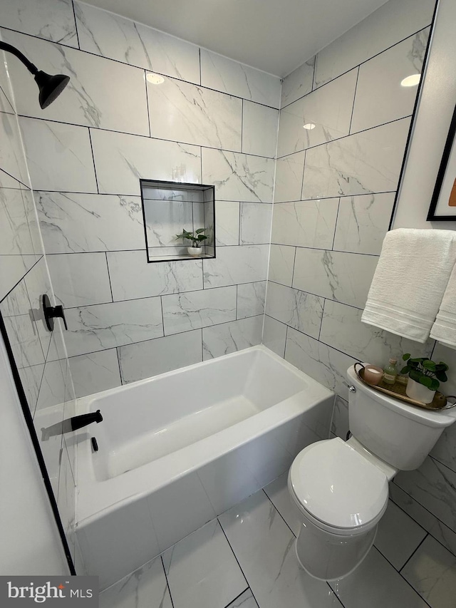 bathroom with toilet, marble finish floor, and bathing tub / shower combination