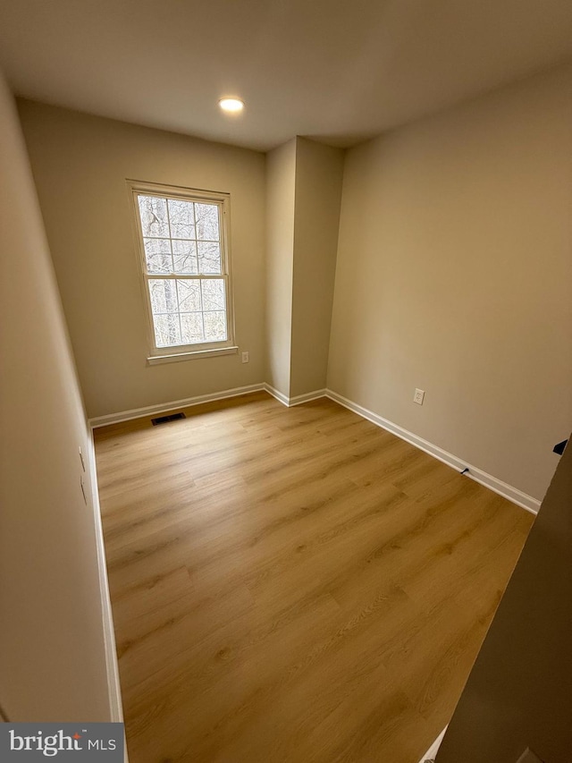 unfurnished room with recessed lighting, wood finished floors, visible vents, and baseboards