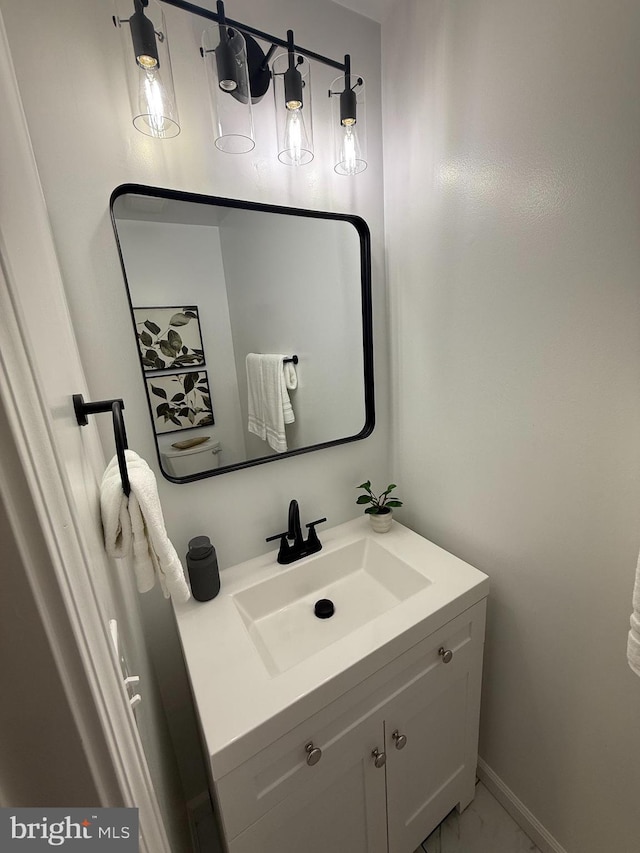 bathroom featuring marble finish floor, vanity, and baseboards