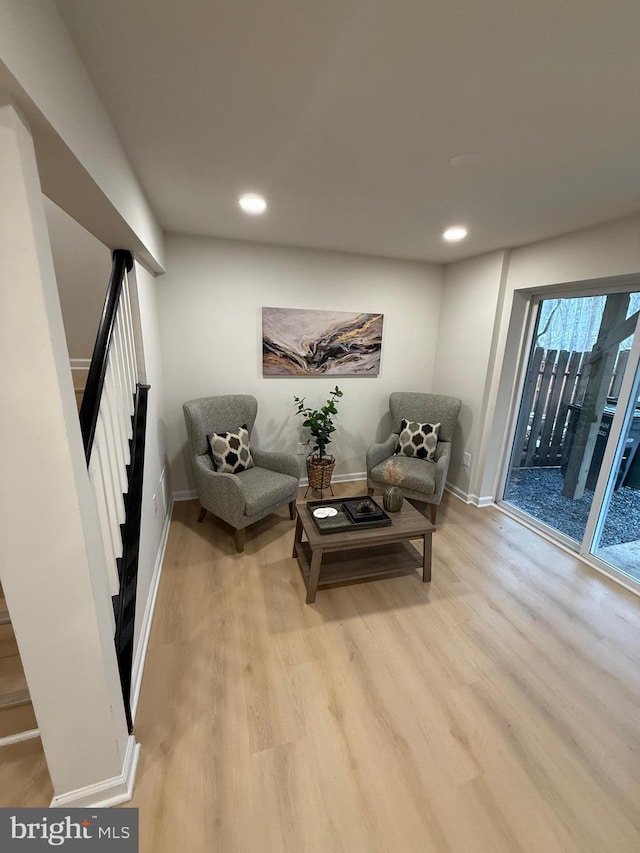 sitting room featuring recessed lighting, light wood finished floors, and stairs