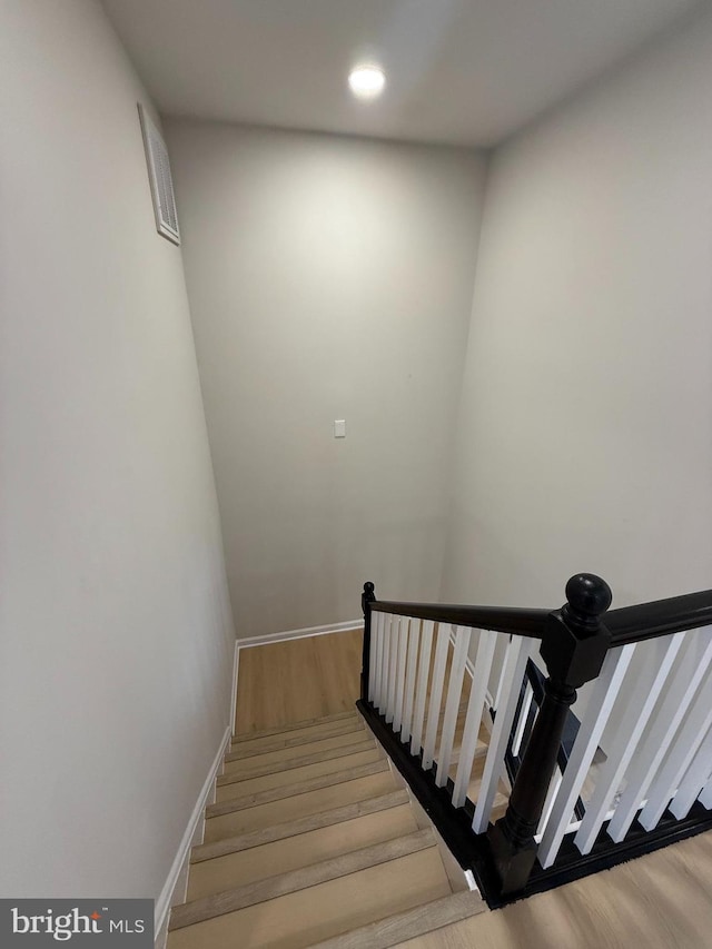 staircase with baseboards, visible vents, wood finished floors, and recessed lighting